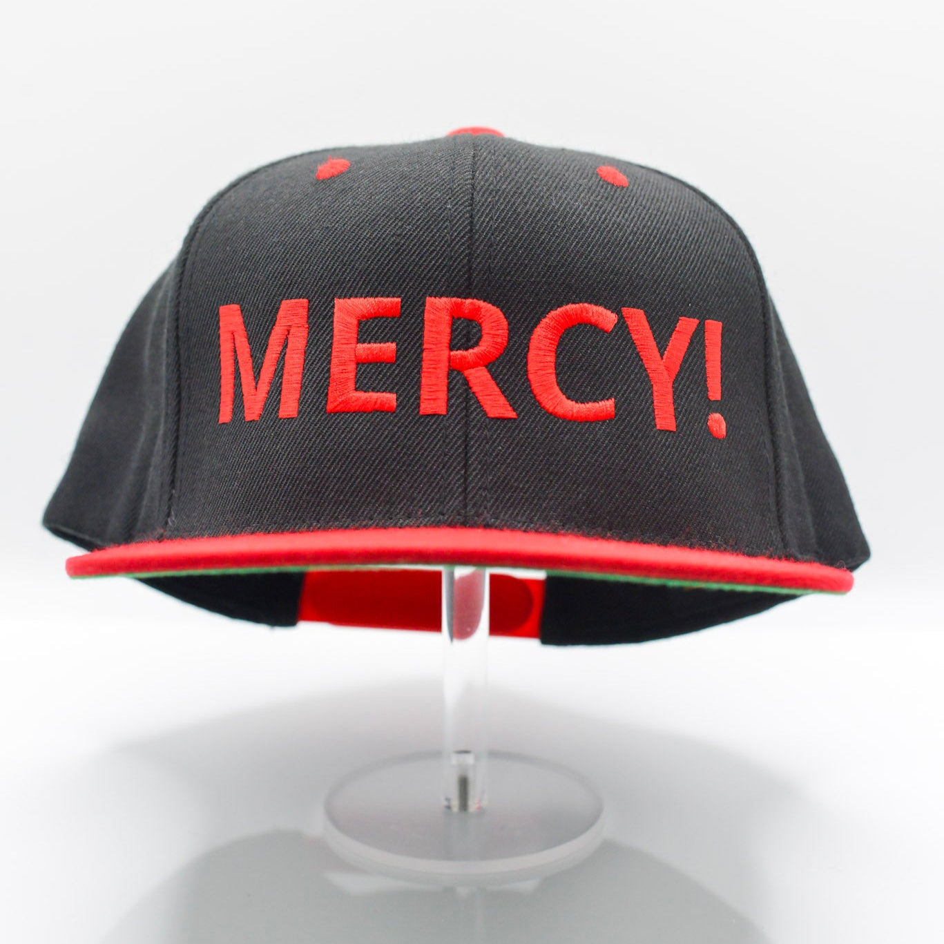 Black snapback with bold red “MERCY!” front embroidery, red brim, and Christian streetwear design by Aaron David Apparel.
