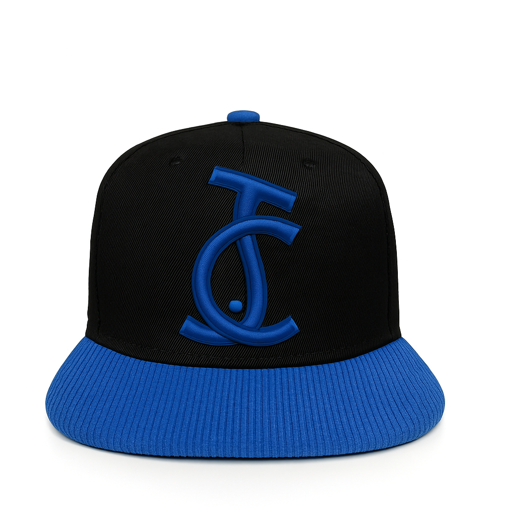 Black snapback hat with a bold royal blue brim and matching 3D JC logo embroidery on the front, part of the Aaron David Apparel faith-inspired collection.